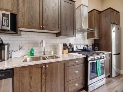 a kitchen with wooden cabinets and a sink and a stove at Amazing Oceanfront & Eagle Views pet Friendly - 2 bath in Port Renfrew
