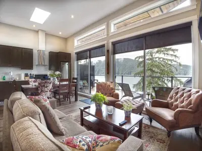 a living room with couches and chairs and a kitchen at Amazing Oceanfront & Eagle Views pet Friendly - 2 bath in Port Renfrew
