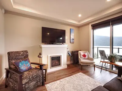 a living room with a fireplace and a tv at Oceanfront Relaxing & Stunning View - Pet Friendly in Port Renfrew