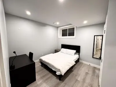 a small bedroom with a bed and a mirror at Private 1BR Basement Suite in NE Calgary in Calgary