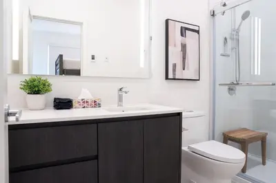 a bathroom with a sink and a toilet and a mirror at The Ridge - 3 Bedroom Condo - Roof Top Hot Tub in Revelstoke