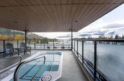 a balcony with a hot tub and a view of the water at The Ridge - 3 Bedroom Condo - Roof Top Hot Tub in Revelstoke