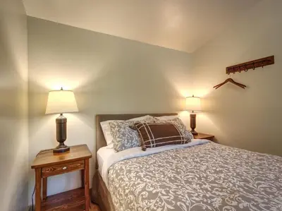 a bedroom with a bed and two lamps on tables at A slice of paradise with Hot Tub - Pet Friendly in Port Renfrew