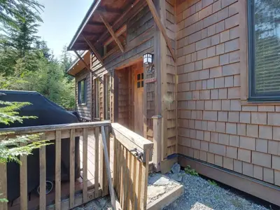 a front porch of a house with a deck at A slice of paradise with Hot Tub - Pet Friendly in Port Renfrew