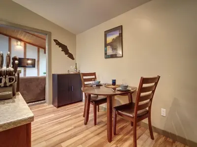 a kitchen and dining room with a wooden table and chairs at Private treed setting - no pets - garden view in Port Renfrew