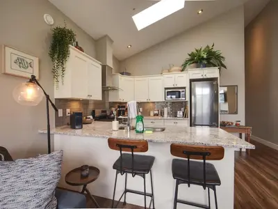 a kitchen with a counter and stools in a room at Oceanfront Marina & Mountain views- pet friendly in Port Renfrew