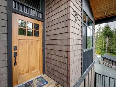 a wooden door on a house with a porch at Oceanfront Marina & Mountain views- pet friendly in Port Renfrew