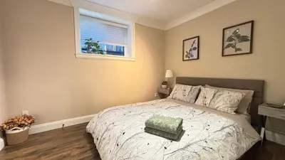 a bedroom with a bed with a green pillow on it at Chic suite close to UBC in Vancouver