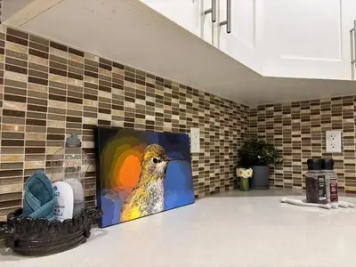a painting of a bird on the wall of a kitchen at Chic suite close to UBC in Vancouver