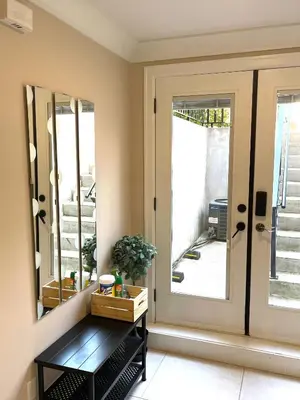 aoyer with a door and a table with a mirror at Chic suite close to UBC in Vancouver