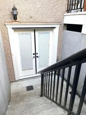 a pair of doors on a building with a staircase at Chic suite close to UBC in Vancouver