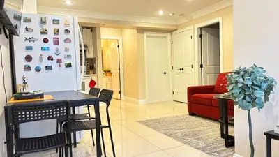 a living room with a table and a red couch at Chic suite close to UBC in Vancouver