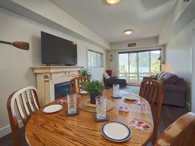 a dining room with a table with chairs and a fireplace at Oceanfront view 2 entertainment areas -Pet Friendly in Port Renfrew