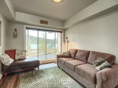a living room with a couch and a window at Oceanfront view 2 entertainment areas -Pet Friendly in Port Renfrew