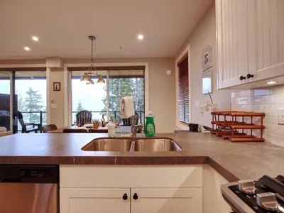 a kitchen with two sinks and a counter top at The Salty Dog - Oceanfront Getaway - Great View - Pet Friendly in Port Renfrew