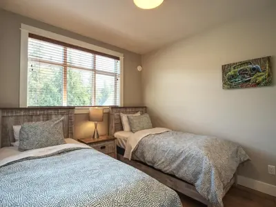 a bedroom with two beds and a window at Oceanfront & Amazing Views - Pet Friendly - 2bdrm in Port Renfrew
