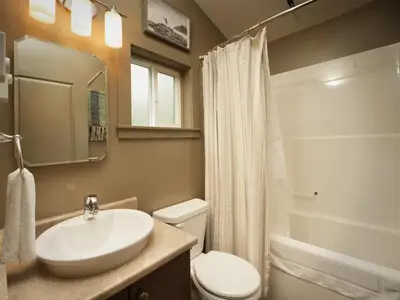 a bathroom with a sink and a toilet and a mirror at The Rocky Knoll - Garden View - Pet Friendly in Port Renfrew