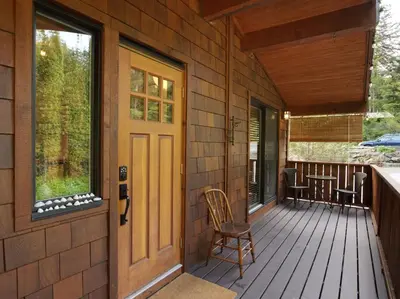 a front porch of a house with a wooden door at The Rocky Knoll - Garden View - Pet Friendly in Port Renfrew