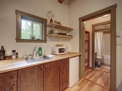 a kitchen with a sink and a microwave on a counter at The Rocky Knoll - Garden View - Pet Friendly in Port Renfrew