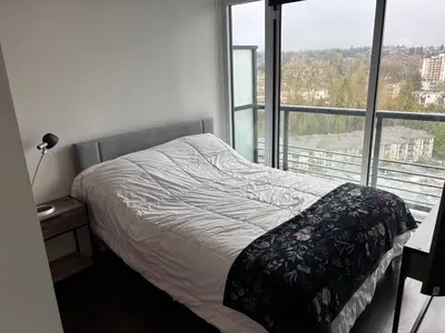 a bedroom with a bed and a large window at Sleek Urban 1BR Retreat in Burnaby