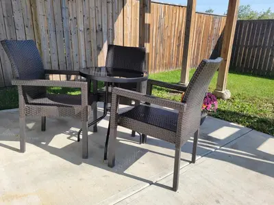 three chairs and a table in a yard at Quaint Lonsdale Suite in Red Deer