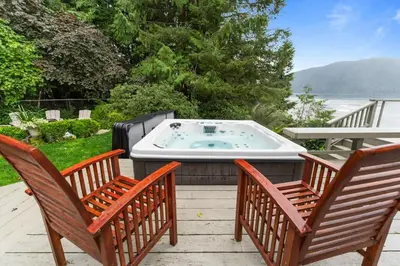 two chairs and a hot tub sitting on a patio at Hot tub - Sauna - Panoramic Ocean View THE POINT - Pet Friendly in Port Renfrew