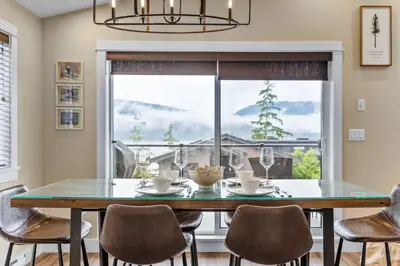 a dining room with a table and chairs and a window at Oceanview - Pet Friendly - Gas Fireplace - Wild Beauty in Port Renfrew