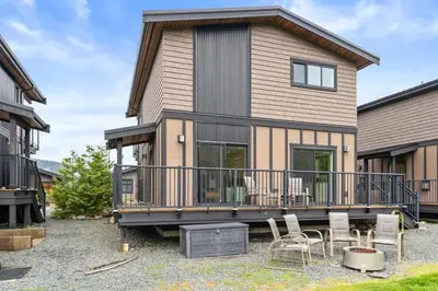 a house with a deck and chairs in front of it at Oceanview - Pet Friendly - Gas Fireplace - Wild Beauty in Port Renfrew