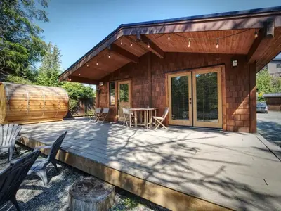 a house with a patio with a table and chairs at Explorers Retreat Private Sauna - Pet Friendly in Port Renfrew