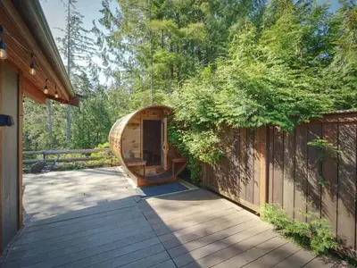 a wooden deck with a sauna on the side of a house at Explorers Retreat Private Sauna - Pet Friendly in Port Renfrew