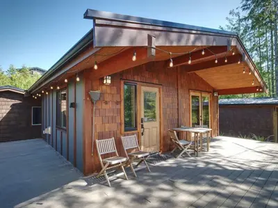 a house with chairs and a table in front of it at Explorers Retreat Private Sauna - Pet Friendly in Port Renfrew