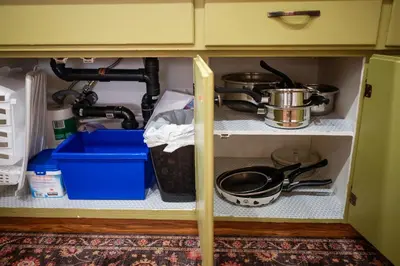 a kitchen cabinet with pots and pans on it at Spacious 2-Bedroom Basement Suite in Whitehorn, Close to Calgary Airport, Hospital, & Train in Calgary