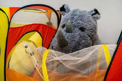 a stuffed teddy bear is sitting in a suitcase at Family Condo w Kids Den FREE Banff Pass in Calgary