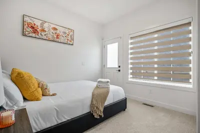a bedroom with a bed and a window at NEW Family 3BR Upper Suite w Kid's Play Den, Free Banff Pass in Calgary