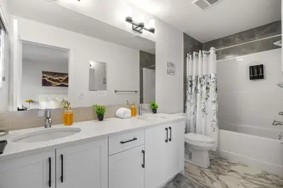 a white bathroom with a sink and a toilet at NEW Family 3BR Upper Suite w Kid's Play Den, Free Banff Pass in Calgary