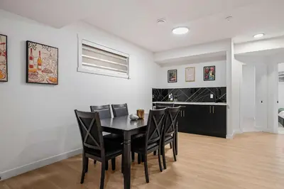 a dining room with a black table and chairs at Large 5BR Family Home w Kids Play Den & Private Basement Suite Included, FREE Banff Pass! in Calgary