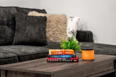 a pile of books on a coffee table in front of a couch at Large 5BR Family Home w Kids Play Den & Private Basement Suite Included, FREE Banff Pass! in Calgary