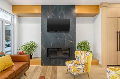 a living room with a fireplace and a yellow chair at Trendy Bridgeland, Fireplace, King Beds, AC in Calgary