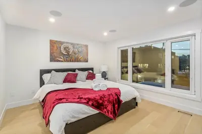 a bedroom with a large bed and a window at Trendy Bridgeland, Fireplace, King Beds, AC in Calgary