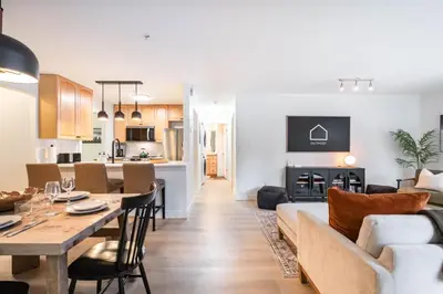 a living room and kitchen with a couch and a table at Wintergreen 26 by Outpost Whistler in Whistler