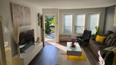 a living room with a couch and a tv at Modern Coastal 2BR Retreat with Private Hot Tub in Vancouver BC in West Vancouver