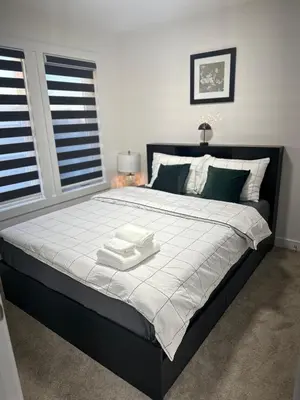 a bedroom with a large bed with two towels on it at Brand New 3 Bedroom house SW Edmonton in Edmonton