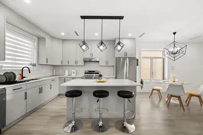 a kitchen with a island with bar stools at Bright Modern 3 Bedroom Suite in Vancouver in Vancouver