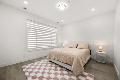 a white bedroom with a bed and a window at Bright Modern 3 Bedroom Suite in Vancouver in Vancouver
