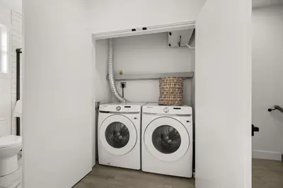 a laundry room with two washing machines and a toilet at Bright Modern 3 Bedroom Suite in Vancouver in Vancouver