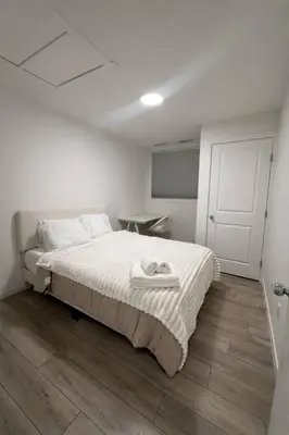 a white bedroom with a bed with a white blanket at Condo w 2 Beds 13 Mins from West Edmonton Mall in Edmonton