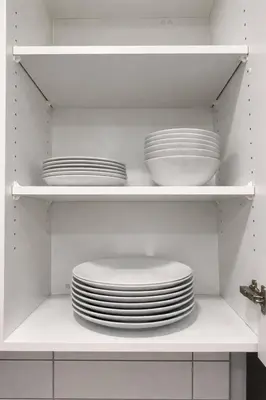 a stack of plates and bowls on shelves in a kitchen at Condo w 2 Beds 13 Mins from West Edmonton Mall in Edmonton