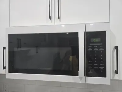 a microwave oven in a kitchen with white cabinets at Cy Becker Drive 2023 Luxury Home in Edmonton