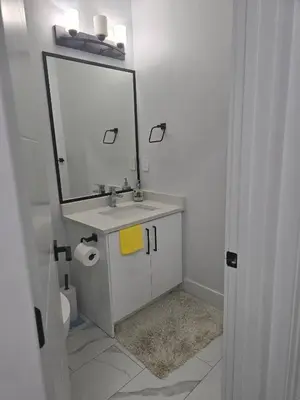 a bathroom with a sink with a mirror and a toilet at Cy Becker Drive 2023 Luxury Home in Edmonton