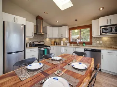 a kitchen with a wooden table with chairs around it at Going Coastal AB - Oceanfront - Pet Friendly in Port Renfrew